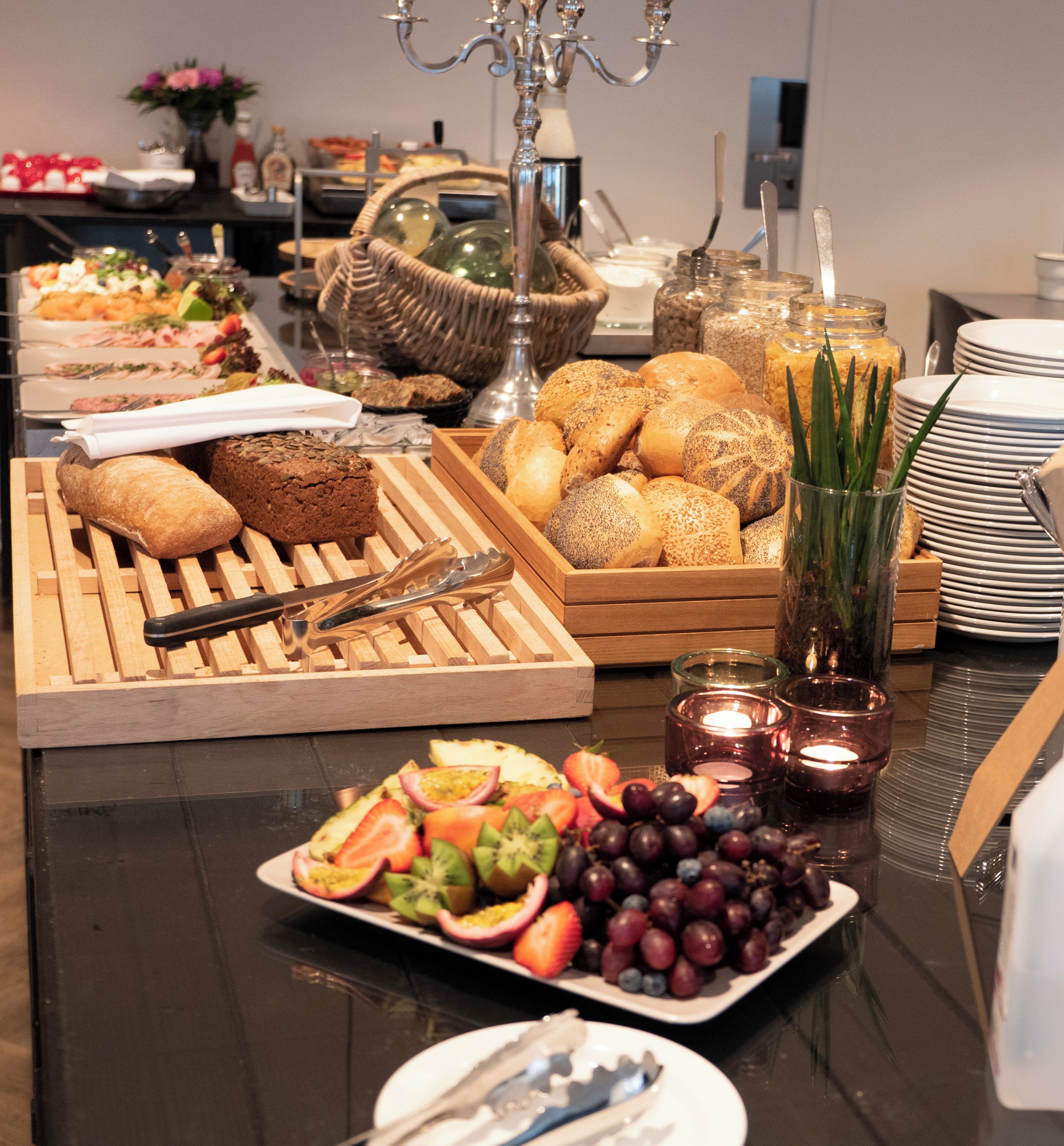 A buffet table with various food items and utensils.