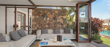 A modern living room with a stone wall, a sofa, and a coffee table.