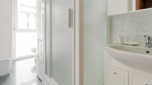 Un baño con ducha, inodoro y lavamanos.