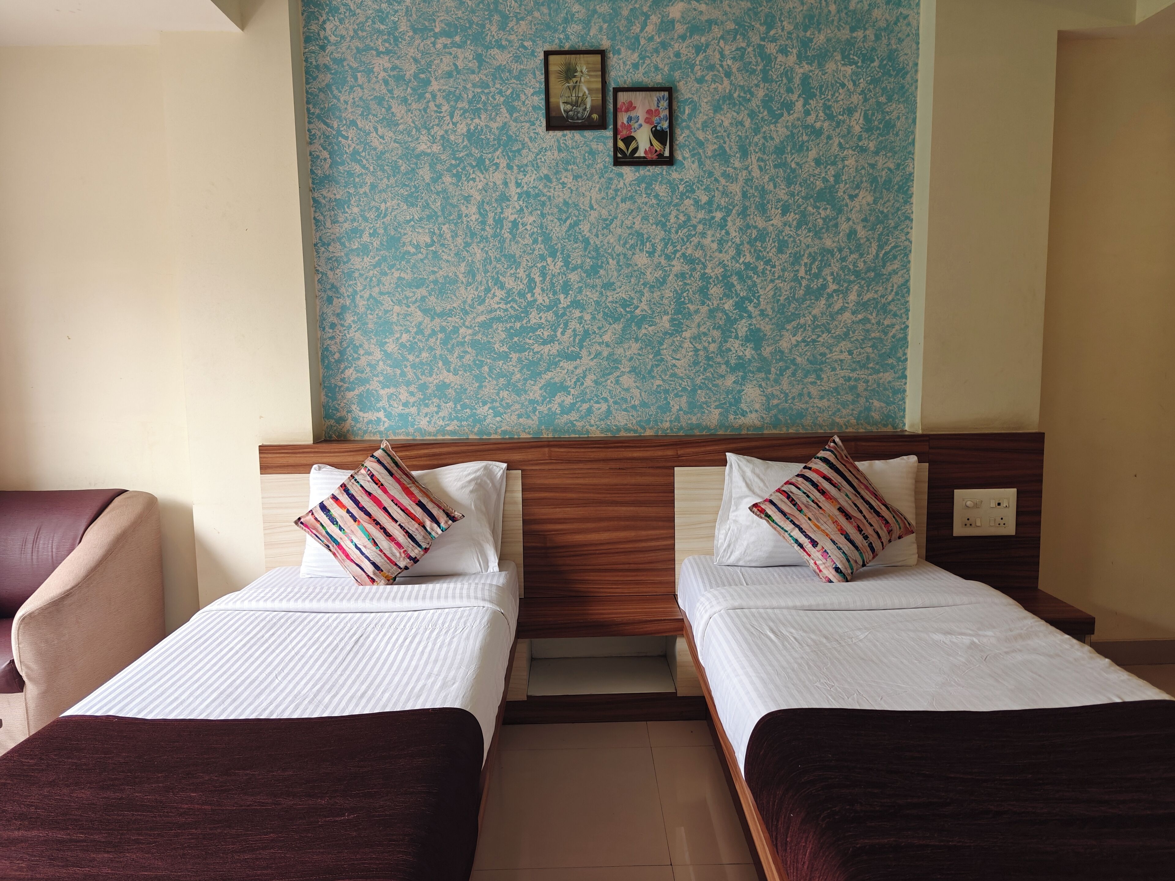 Two single beds with wooden headboards, white bedding, and striped pillows.