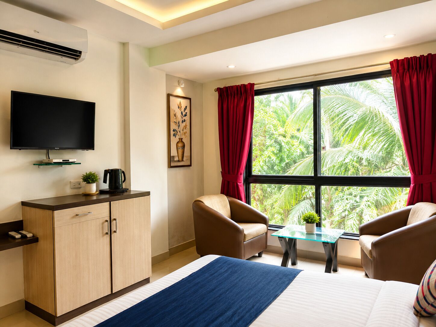 Ein Hotelzimmer mit Bett, Fernseher, Schreibtisch, Stuhl, Tisch und einem Fenster mit Vorhängen.