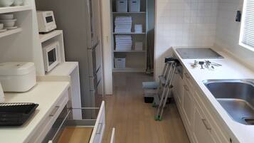 Frigorífico grande, microondas, placa de cocina y utensilios de cocina