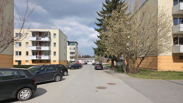 A residential street with parked cars, apartment buildings, and a tree-lined sidewalk. - Richie Apartment Near Aquapark (Prague)