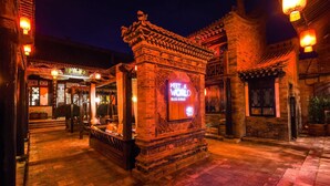 Een traditionele Chinese binnenplaats met een bord waarop staat 'MEET A WORLD'.
