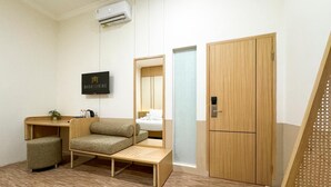 Ein modernes Zimmer mit einem Bett, einem Schreibtisch, einem Stuhl und einem Kleiderschrank.