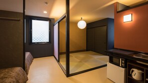 A compact hotel room with a sliding door leading to a balcony, a kitchenette with a microwave and kettle, and a large window with a checkered pattern. - Doyanen Hotels Kingyo (Osaka)