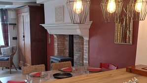 A modern kitchen with a wooden island, hanging pendant lights, and a brick fireplace. - Sunset de Bénévent, country cottage for 4 to 6 people (Bénévent-l'Abbaye)