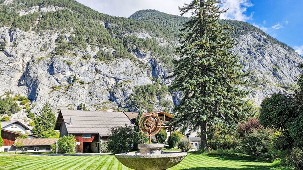 A mountain landscape with a stone fountain, a wooden house, and a large tree in the foreground. - Acereto by Interhome (Nassereith)