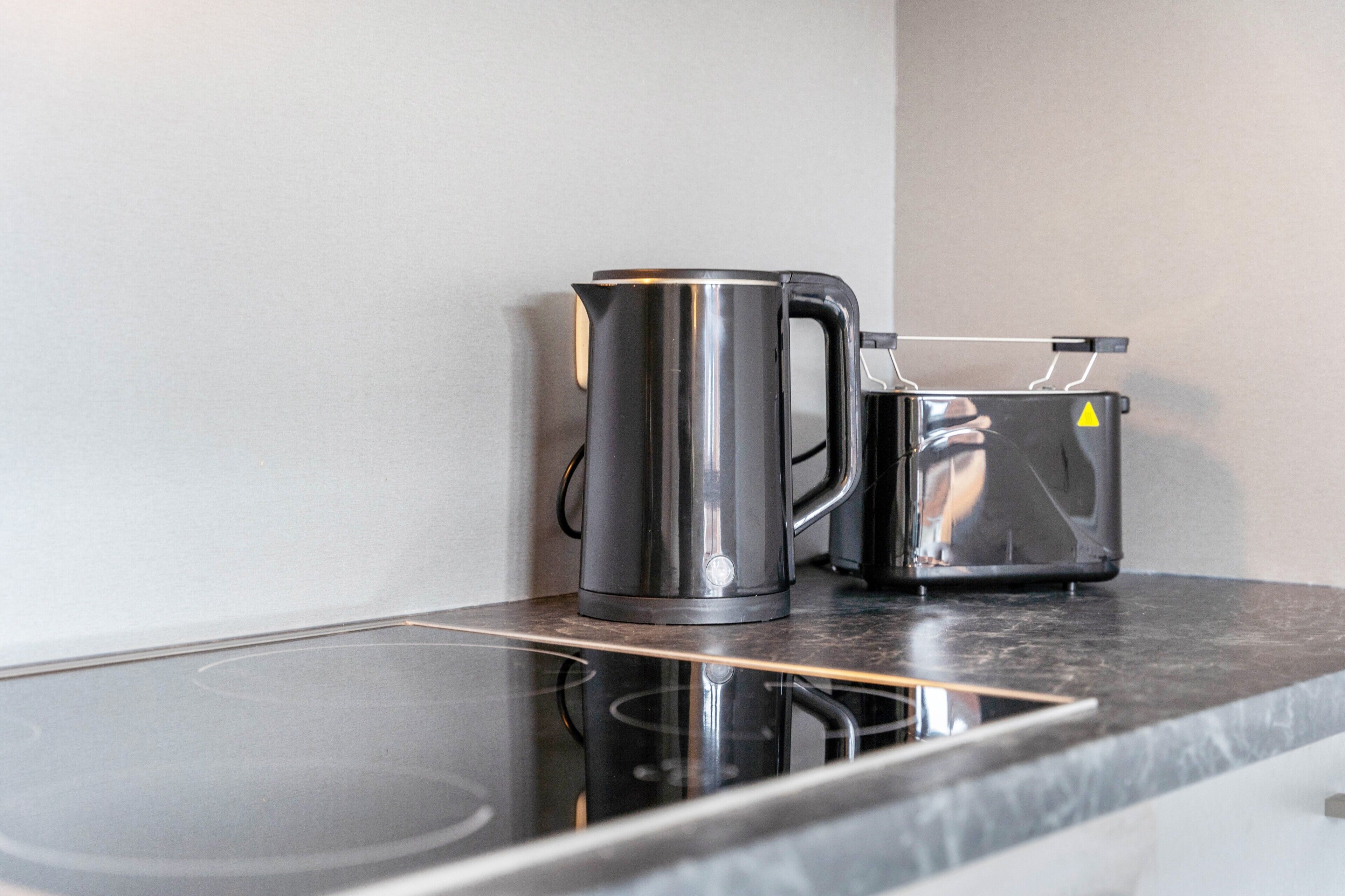 Eine Küchenarbeitsplatte mit einem Edelstahl-Wasserkocher und einer Kaffeemaschine.