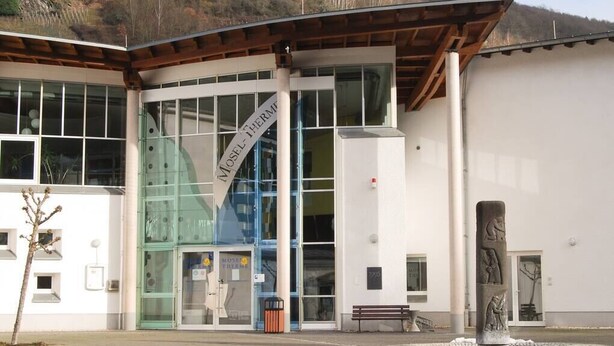 Een modern gebouw met grote glasramen en een opvallende ingang.