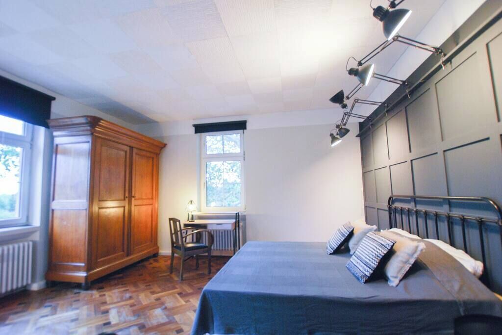 A bedroom with a bed, a desk, a chair, and a wardrobe.