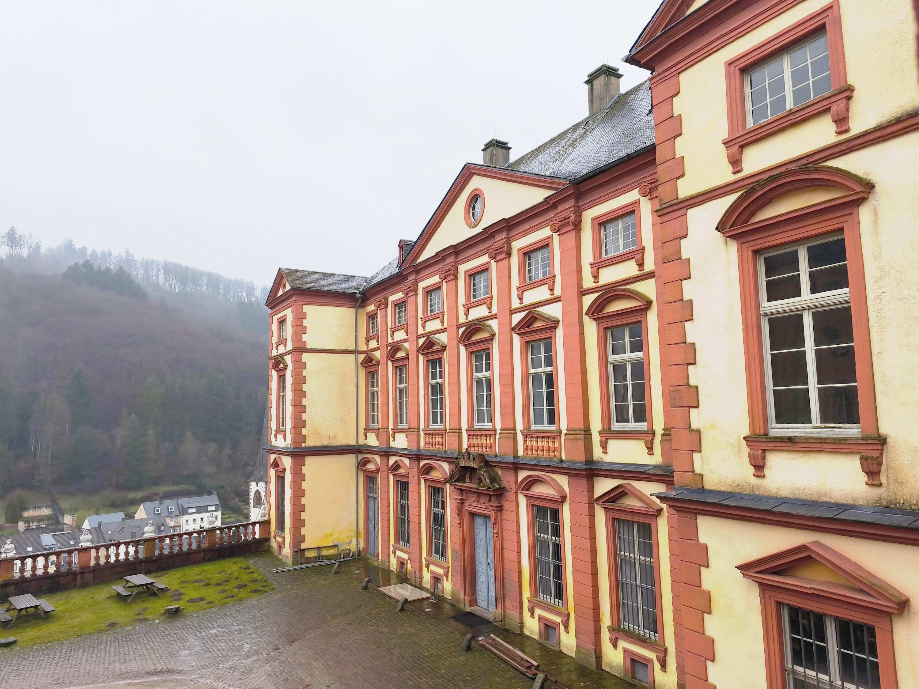 A large, historic building with multiple windows and a courtyard.