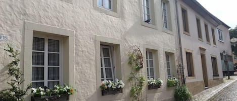 Un immeuble doté de nombreuses fenêtres et de jardinières au rez-de-chaussée.