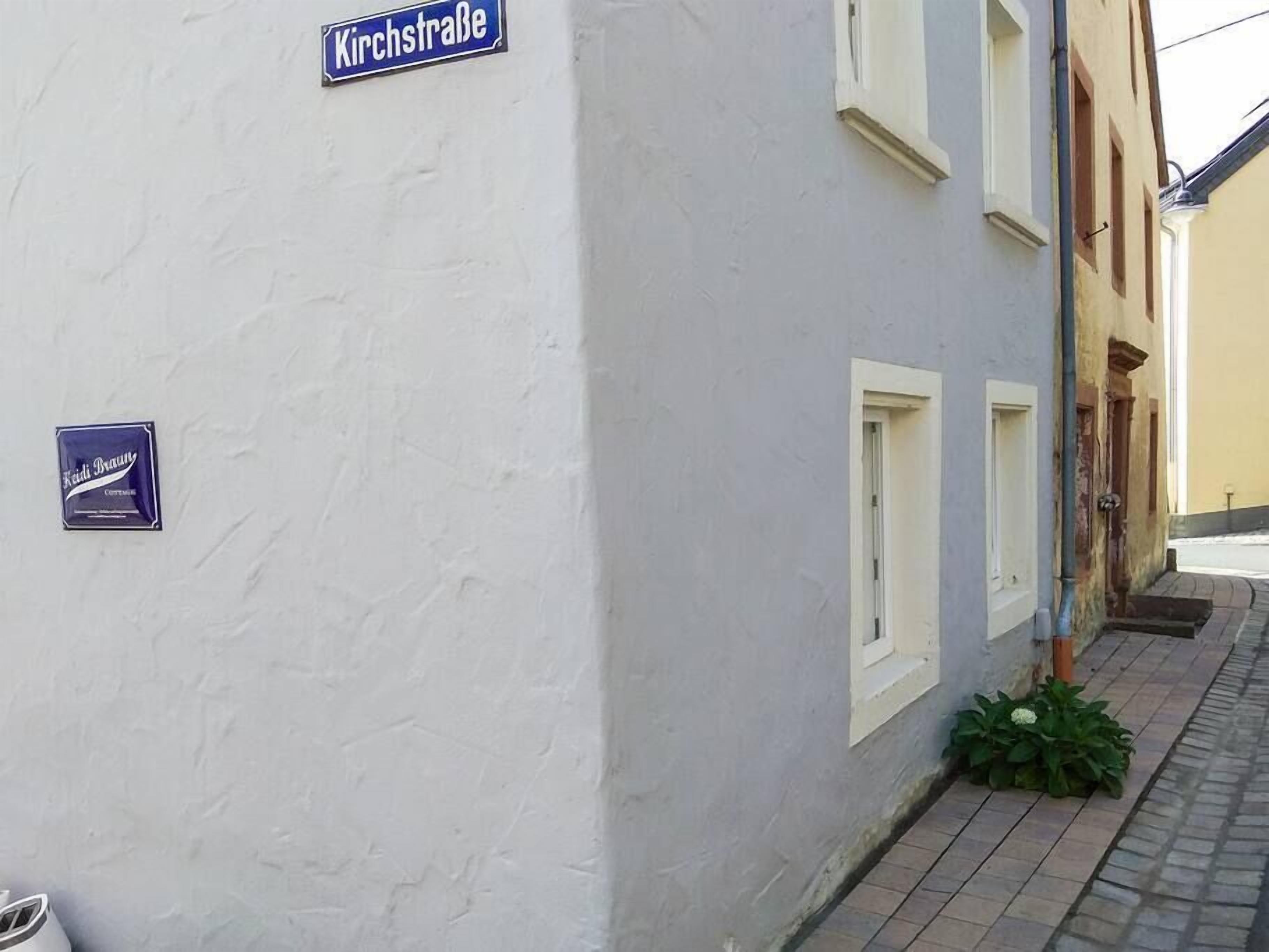 Kapea katu, jonka varrella on valkoinen rakennus, kyltti, jossa lukee ”Kirchstraße”, ja pieni kyltti, jossa on teksti ”Keidi Brauerei”.