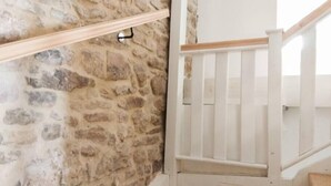 A stone wall with a wooden beam and a white railing. - Living in history: Heidi Braun Cottage (Dudeldorf)