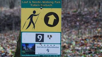 Lauf & Nordic Walking Park Traben-Trarbach -puiston opastekyltti, jossa nuoli osoittaa ylöspäin ja merkiten kävelyreitin suuntaa.