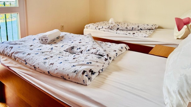 A hotel room with two beds, each with a floral-patterned duvet and pillows. - Spacious Stone Villa With Sea Views (Dubrovnik)