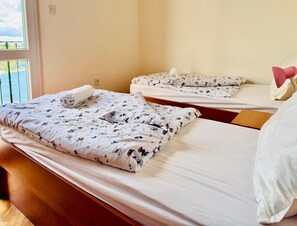 Una habitación de hotel con dos camas, cada una con edredón y almohadas estampadas con motivos florales.
