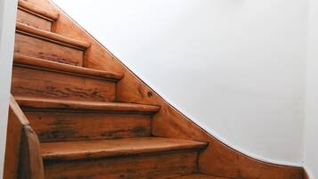 A wooden staircase with a white wall at the top.