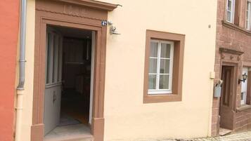 Un edificio con facciata beige, ingresso a cornice marrone e una piccola finestra.