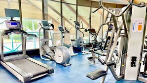 Een sportschool met loopbanden, elliptische trainers en gewichten.