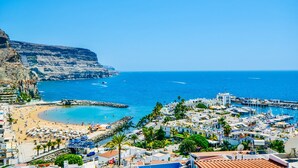 A coastal town with a beach, marina, and buildings. - Best View in Puerto de Mogán | Panoramic Terrace (Lomo Quiebre)