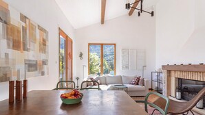 A dining area with a wooden table, chairs, and a bowl of fruit. - Casa Vermella with Pool and Terrace (Sorède)