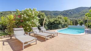 A poolside area with lounge chairs, a pool, and a mountainous backdrop. - Casa Vermella with Pool and Terrace (Sorède)