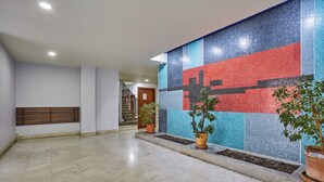 A spacious lobby with a tiled wall, potted plants, and a staircase. - Sublime AC Apartment Eiffel Tower Champs de Mars (Paris)