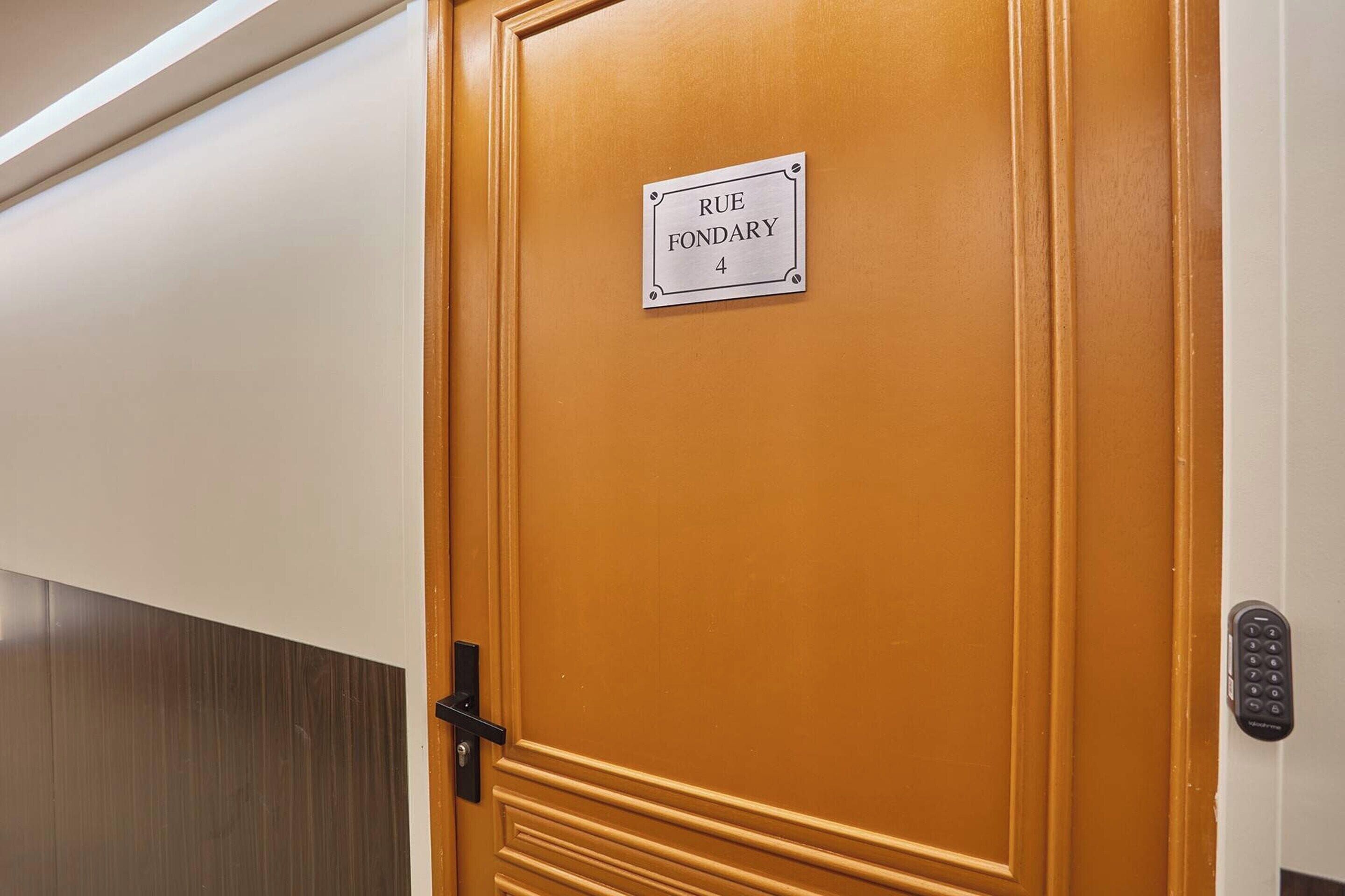 Une porte en bois portant une plaque avec l’inscription « RUE FONDARY 4 ».