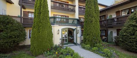 A hotel with a central courtyard, a covered entrance, and multiple balconies.