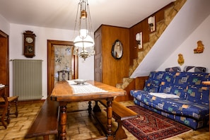 A dining area with a wooden table, bench, and chandelier.
