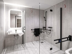 A modern bathroom with a glass-enclosed shower, a white sink, and a toilet.