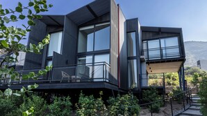 A modern two-story house with large windows, a balcony, and a view of the surrounding landscape. - Pueblo La Dehesa (Lo Barnechea)