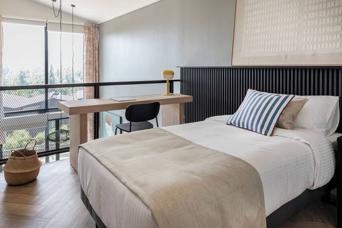Une chambre à coucher avec un lit, un bureau et une chaise.