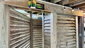Una struttura in legno con pareti a listelli e un cartello che indica gli spogliatoi.