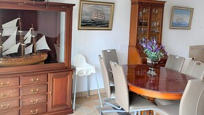 A dining area with a wooden cabinet, a ship model, and a dining table with chairs. - Park Brekkense Wiel 173 (Lemmer)