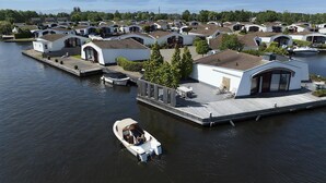 Een jachthaven met moderne huizen, een steiger en een boot.