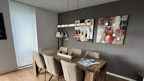 A modern dining area with a wooden table, six chairs, and two pendant lights. - Park Brekkense Wiel 038 (Lemmer)