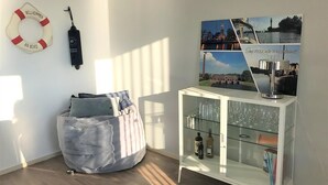 A room with a bean bag chair, a white cabinet with glass doors, a life preserver, and a wall-mounted lamp. - Park Brekkense Wiel 229 (Lemmer)