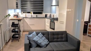 A modern kitchen with a built-in stove, sink, and a small dining area. - Park Brekkense Wiel 103 (Lemmer)