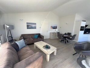 Una sala de estar moderna con sofá, mesa de centro y comedor.