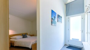 A bedroom with a bed, a door, and a small entryway. - Bungalow at the waterside pets friendly (Lemmer)