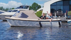 Un bateau était amarré dans une marina, avec un bâtiment moderne en arrière-plan.