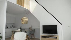 Un appartement moderne de style « loft » comprenant un coin repas, une cuisine et un espace de vie.