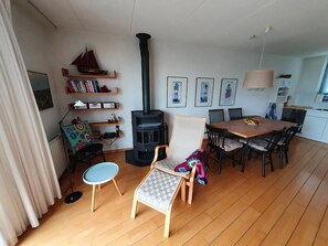 Un salon moderne avec une cheminée, un coin repas et une cuisine.
