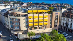 A hotel with a rooftop terrace, multiple balconies, and a view of the sea. - Astra Studio (Vevey)