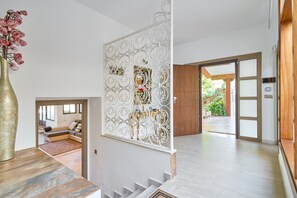 A modern interior with a staircase, a decorative white panel, and a view of an outdoor area. - Villa 'Dopimar' with Private Pool, Wi-Fi and Air Conditioning (Rincón de la Victoria)