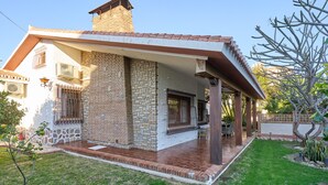 Una casa amb façana de maó, un porxo cobert i un petit jardí.