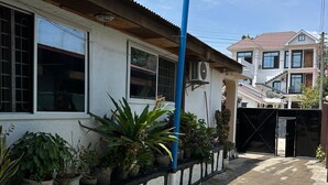 A residential area with a paved walkway, potted plants, and a blue pole. - Karibu nest hostel (Dar es Salaam)